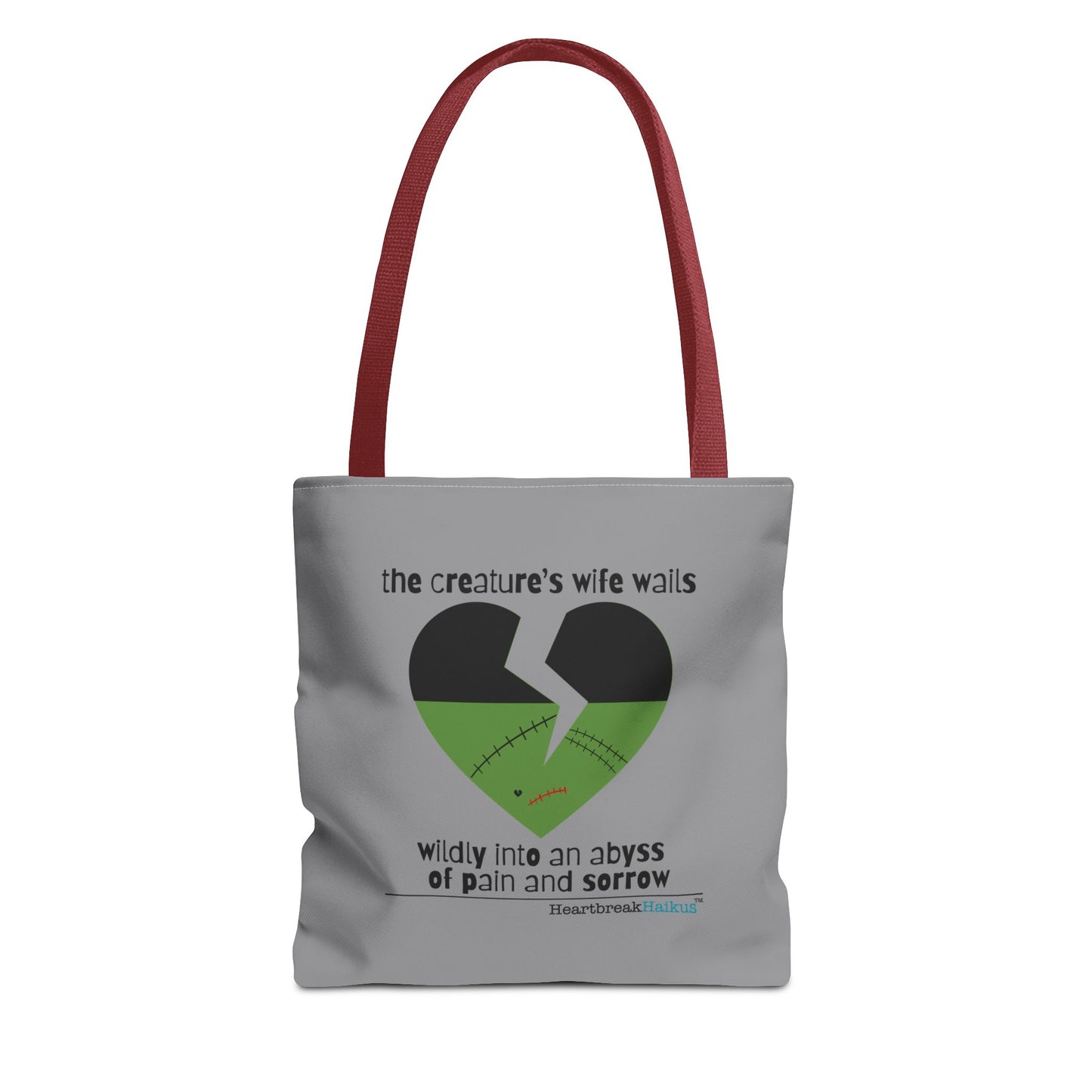 The Creature's Wife Wails Frankenstein Haiku tote bag in stone grey with heart graphic and red handles.
