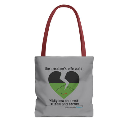 The Creature's Wife Wails Frankenstein Haiku tote bag in stone grey with heart graphic and red handles.