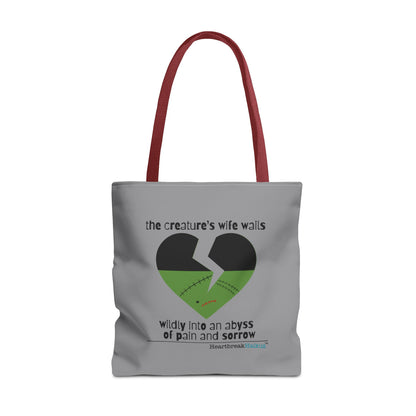Frankenstein haiku tote bag featuring a heart design with text expressing sorrow and pain, stone grey tote with red handles.
